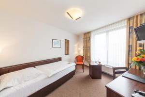 una camera d'albergo con letto e scrivania di Hotel Strijewski a Wolfsburg