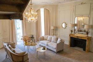 馬夫列的住宿－Hôtel Chateau de Maffliers - Demeures de Campagne，带沙发和吊灯的客厅