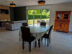 a dining room with a table and chairs and a couch at Gite : La maison d'Apolline in Tréhorenteuc