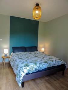 1 dormitorio con cama y pared verde en Gite : La maison d'Apolline, en Tréhorenteuc