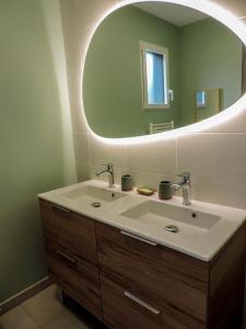 baño con lavabo y espejo grande en Gite : La maison d'Apolline en Tréhorenteuc
