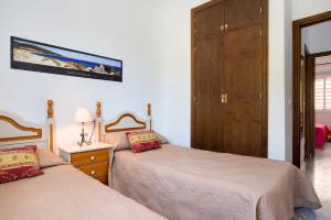 コニル・デ・ラ・フロンテーラにあるApartamento Mediterraneo 105のベッドルーム1室(ベッド2台、木製キャビネット付)