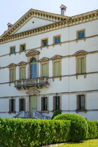 Edificio blanco con ventanas y balcón en Residenza Villa Vecelli Cavriani, en Mozzecane