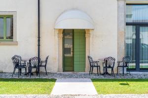 a group of chairs sitting around a table in front of a building at Residenza Villa Vecelli Cavriani in Mozzecane