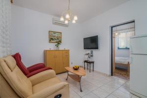 a living room with a couch and a tv at Apartment Dinka in Čižići