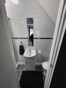 a white bathroom with a sink and a toilet at City Centre Studios 3 in Leicester