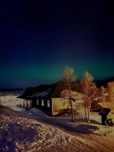 una casa con la aurora en el cielo por la noche en Gullingen Turistsenter, en Gullingen