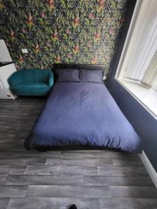 uma cama roxa num quarto com uma parede em City Centre Studios 3 em Leicester