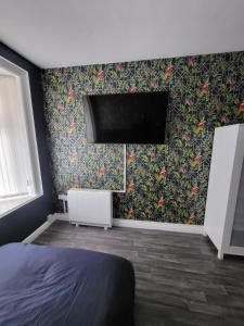 um quarto com uma cama e uma televisão na parede em City Centre Studios 3 em Leicester