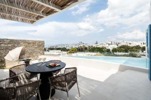 a patio with a table and chairs and a swimming pool at Aura Suites Paros in Naousa