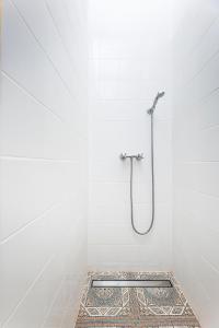 La salle de bains blanche est pourvue d'une douche et d'un sol en mosaïque. dans l'établissement Silvie Apartments - Masaryk dolní, à Olomouc