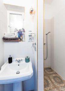 een witte badkamer met een wastafel en een douche bij Silvie Apartments - Masaryk dolní in Olomouc