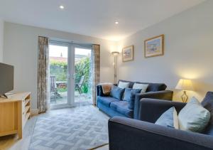 a living room with a blue couch and a tv at The Haven in Southwold