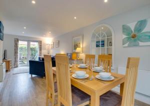 a dining room and living room with a wooden table and chairs at The Haven in Southwold