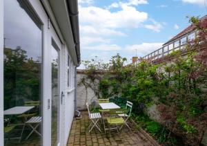 a patio with a table and chairs on a balcony at The Haven in Southwold