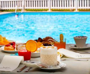 un tavolo con cibo e bevande accanto alla piscina di Centro Vacanze Domus M.G. a San Benedetto del Tronto