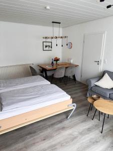 Un dormitorio con una cama, una mesa y un sofá. en Bungalow Süüdstraat, en Norderney