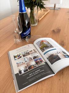 una revista sentada en una mesa con una botella de vino en Bungalow Süüdstraat, en Norderney