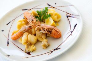 a plate of food with shrimp and pasta on it at Centro Vacanze Domus M.G. in San Benedetto del Tronto