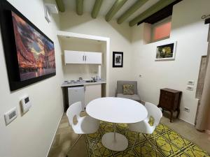 a white dining room with a white table and chairs at Hotel Ortigia Royal Suite in Syracuse