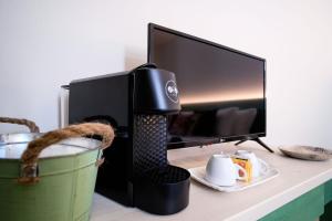 una macchinetta del caffè su una scrivania accanto a una TV di Locanda Il Cavallino a Valeggio sul Mincio