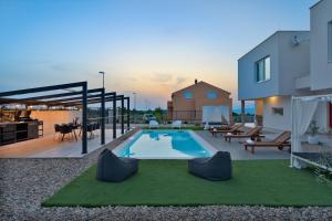 a backyard with a swimming pool and a house at Villa Dream Island in Paljuv
