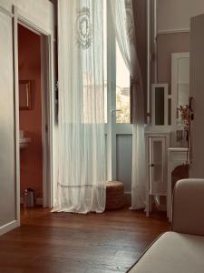una camera con una grande finestra con tende bianche di L.A. CASA IN ALTO a Tricase