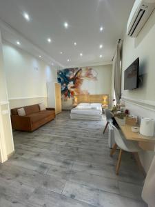 pokój hotelowy z łóżkiem, biurkiem i kanapą w obiekcie Parthenope Rooms w mieście Neapol