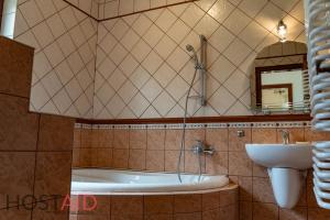 a bathroom with a bath tub and a sink at VILLA57 - Balatonalmádi - hostAID in Balatonalmádi