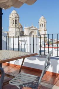 una mesa y una silla en un balcón con 2 torres en El Atico de los INGLESES by Cadiz4Rentals, en Cádiz
