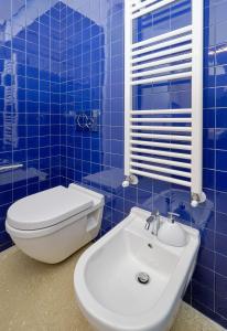 マリーナ・ディ・ラグーザにあるPetrantica Resortの青いタイル張りのバスルーム(トイレ、シンク付)