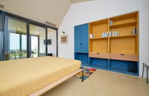 マリーナ・ディ・ラグーザにあるPetrantica Resortのベッドルーム1室(青と黄色のキャビネット付きのベッド1台付)