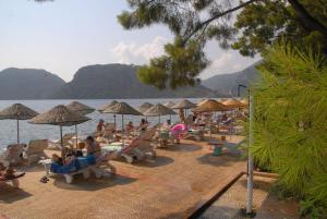 a group of people sitting on a beach with umbrellas at Marmaris Park Hotel in Marmaris