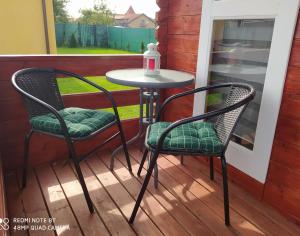 two chairs and a table on a porch at Domki Family Rowy in Rowy