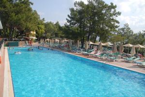a large swimming pool with people in chairs and umbrellas at Marmaris Park Hotel in Marmaris