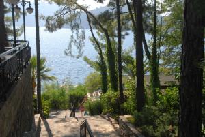 a person walking down a path next to the water at Marmaris Park Hotel in Marmaris