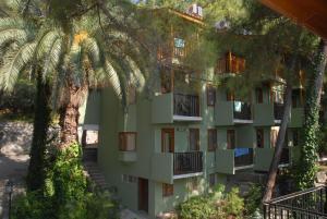an apartment building with trees in front of it at Marmaris Park Hotel in Marmaris