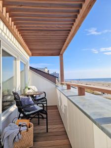 a balcony with chairs and a table on the beach at Boulevard 5 in Zandvoort