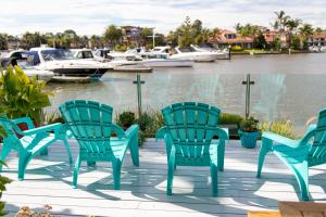 a group of chairs sitting on a deck next to the water at Absolute Waterfront Marina Views in Patterson Lakes