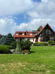 una casa con un césped verde delante de ella en Piękna Góra, en Giżycko