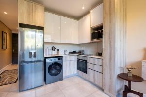 uma cozinha com uma máquina de lavar roupa e uma máquina de lavar louça em Zimbali Lakes Boulevard Suites em Ballito
