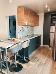 une cuisine avec une table et deux tabourets de bar dans l'établissement SEAYA mobile home - Terra Park SpiritoS, à Kolan