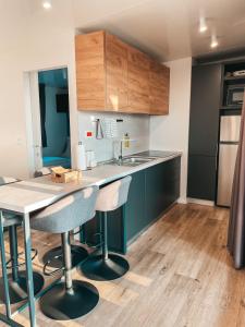 a kitchen with a table and two bar stools at SEAYA mobile home - Terra Park SpiritoS in Kolan