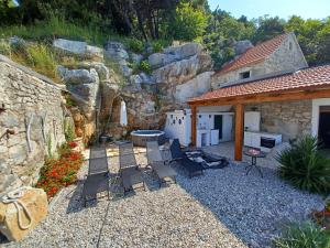 a patio with chairs and a table and a building at Kuća za odmor Leptirić in Pisak