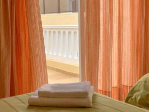 two towels sitting on a bed in front of a window at Bienestar Buenavista by Vive La Exclusividad in Buenavista del Norte