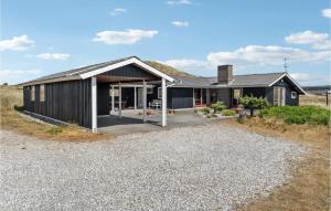 una casa con una facciata nera e un vialetto di ghiaia di Gorgeous Home In Hvide Sande With Sauna a Havrvig