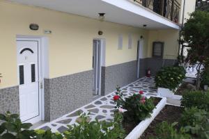 a building with a white door and some plants at Yiannis Studios in Troulos