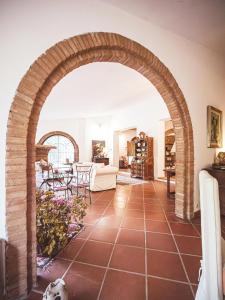 an archway in a living room with a table and chairs at Relais Casale Il Poggetto VILLA PAOLA by Zoom In Earth in Cecina