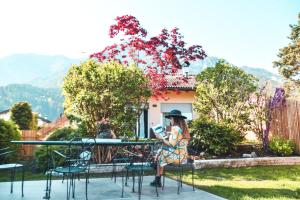 a woman sitting at a table looking at her cell phone at Relax in Pineta in Caldonazzo