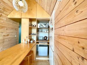 cocina con paredes de madera y encimera de madera en Lushna 4 Petite at Lee Wick Farm Cottages & Glamping, en Clacton-on-Sea